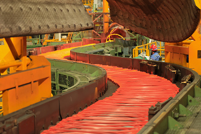 Curved conveyor section feeding Primetals Technologies’ Stelmor Conveyor.
